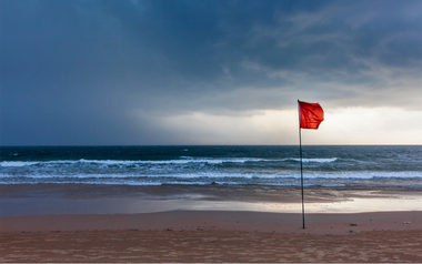 Red flag flying on a beach